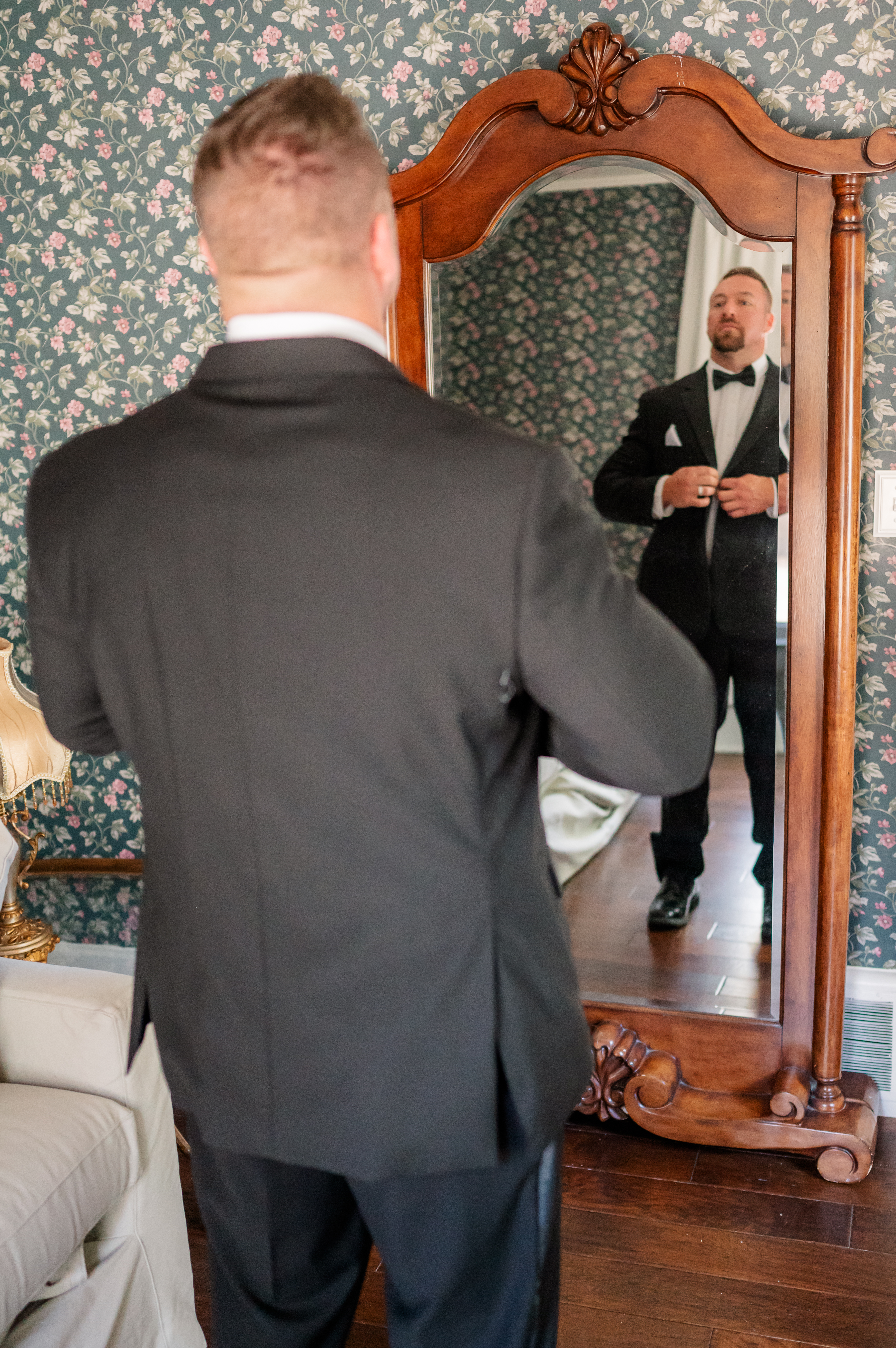 Captured in a candid moment as he carefully buttons up his attire in anticipation of the wedding ceremony.